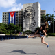 Carolina, a tourist from Chile, jumps while having her picture taken by a friend before a tribute to revolutionary leader Che Guevara in front of the Cuban Interior Ministry (MININT) in Havana's Revolution Square October 8, 2013. Forty-six years after he was captured by soldiers in a Bolivian jungle and executed the next day, the Argentine-born Ernesto Guevara De La Serna, AKA, 'Che', is still a national hero in Cuba where he joined Fidel Castro in an armed uprising that ousted a U.S. backed dictator in 1959. Tuesday will be Guevara's 46th death anniversary. The words on the building read: "Onward to victory, always".